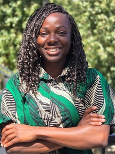 woman in a green shirt with arms folded, smiling